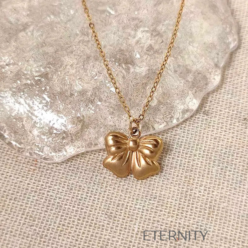 Set de Collar y Zarcillos Charming Bow con Diseño de Lazo Escultural Set Dorado Unica Acero Inoxidable ETERNITY