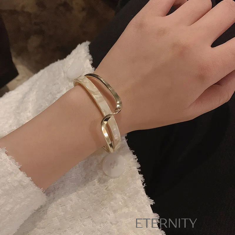 Brazalete dorado con detalle marmoleado blanco elegante Brazaletes Dorado Unica Acero Inoxidable  ETERNITY