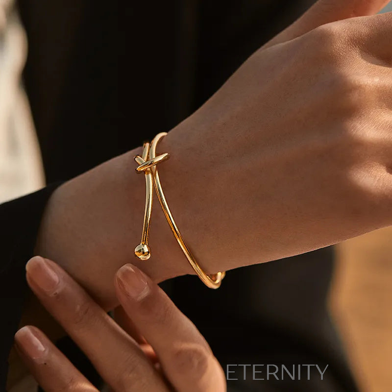 Brazalete Rígido Knot con Nudo Central en Oro  Brazaletes Dorado Unica Acero Inoxidable  ETERNITY