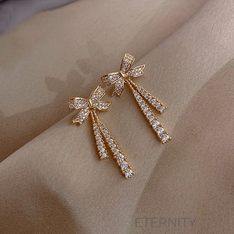 Zarcillos Colgantes Sparkle Bow con Cristales Pavé y Diseño de Lazo  Zarcillos Dorado Unica Acero Inoxidable  ETERNITY