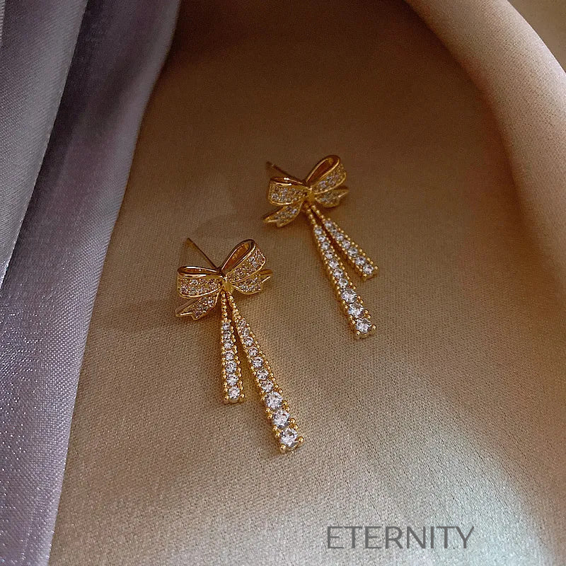 Zarcillos Colgantes Sparkle Bow con Cristales Pavé y Diseño de Lazo  Zarcillos Dorado Unica Acero Inoxidable  ETERNITY