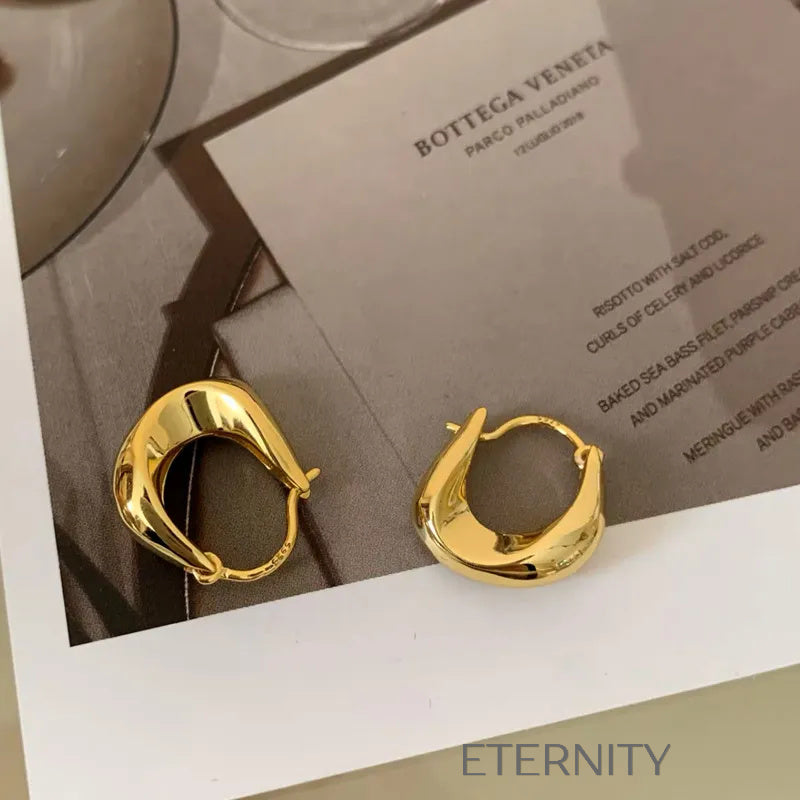Aretes dorados tipo aro con diseño escultórico moderno Zarcillos Dorado Unica Acero Inoxidable  ETERNITY