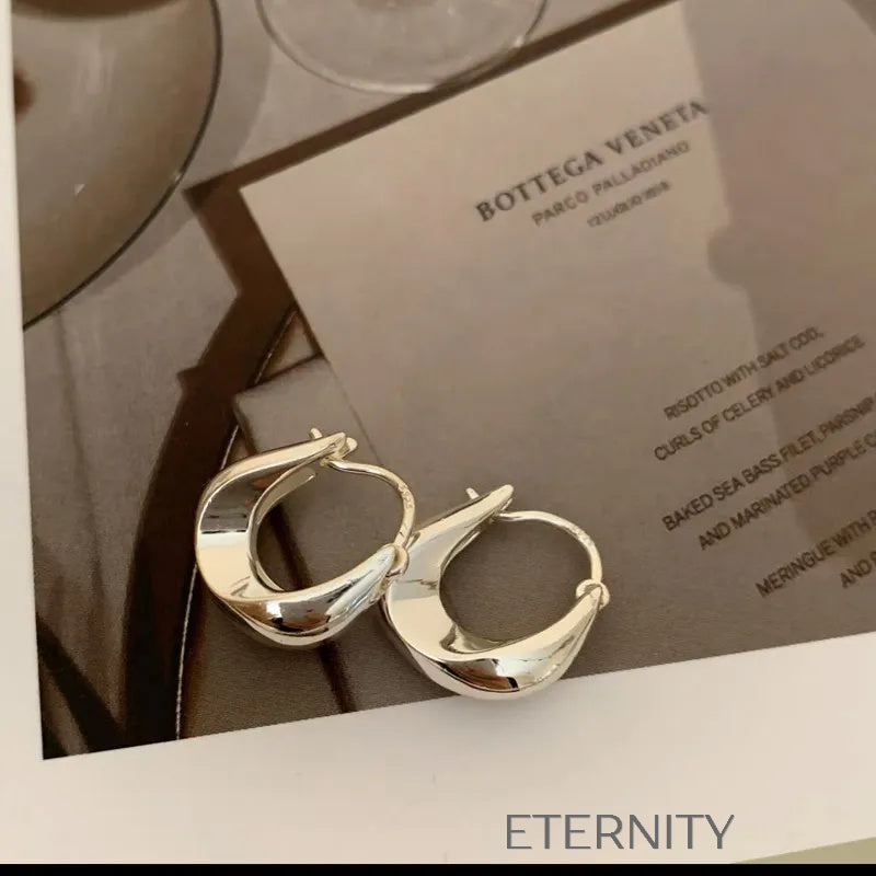 Aretes dorados tipo aro con diseño escultórico moderno Zarcillos Dorado Unica Acero Inoxidable  ETERNITY