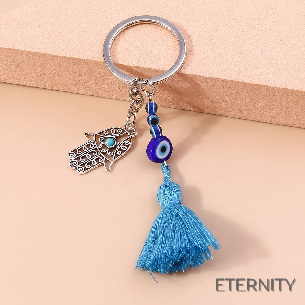 Llavero Plateado con Ojo Turco, Mano de Hamsa Calada y Borla Azul - ETERNITY