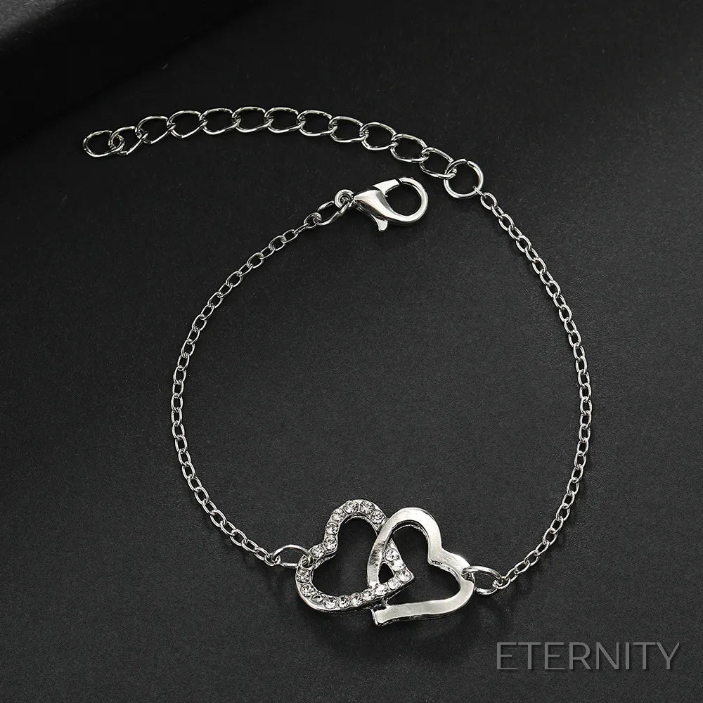 Conjunto Femenino de Cuatro Piezas: Corazones Entrelazados en Dorado: Cadena, Pulsera, Anillo y Zarcillos - ETERNITY