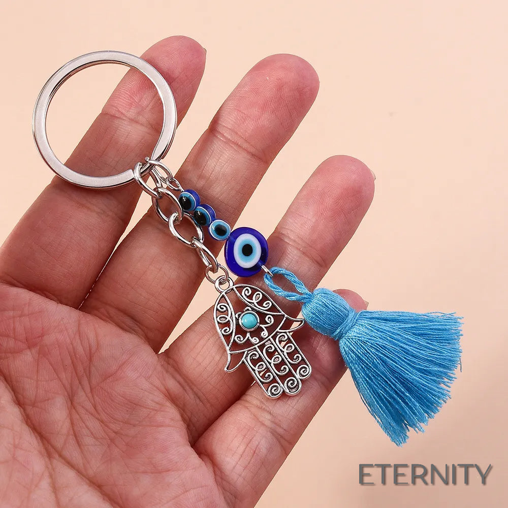 Llavero Plateado con Ojo Turco, Mano de Hamsa Calada y Borla Azul - ETERNITY