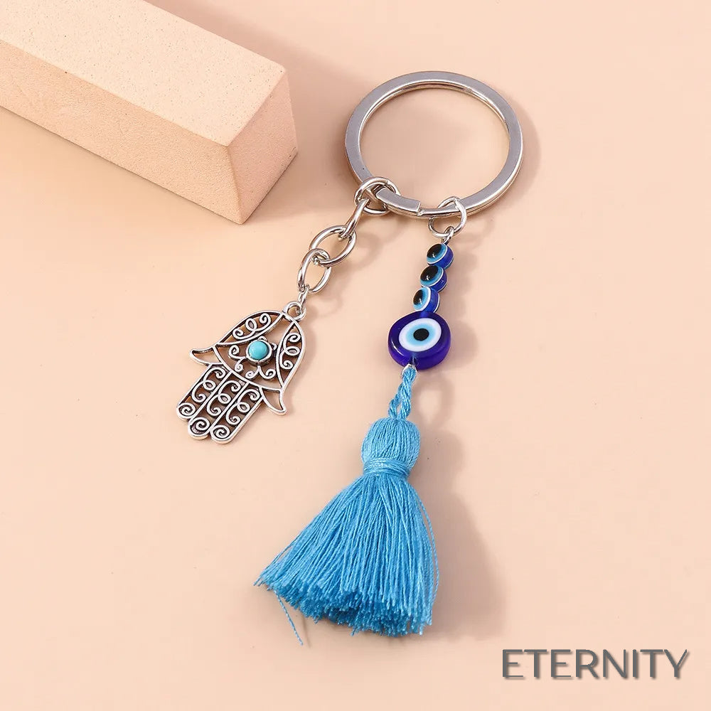 Llavero Plateado con Ojo Turco, Mano de Hamsa Calada y Borla Azul - ETERNITY